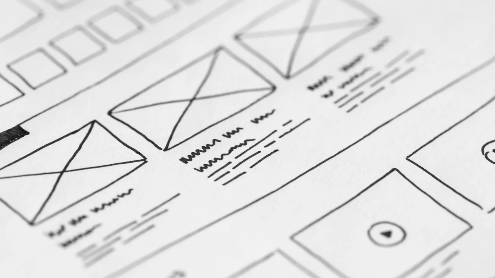 Escritorio de trabajo con laptop mostrando el rediseño web de una panadería, wireframes y café